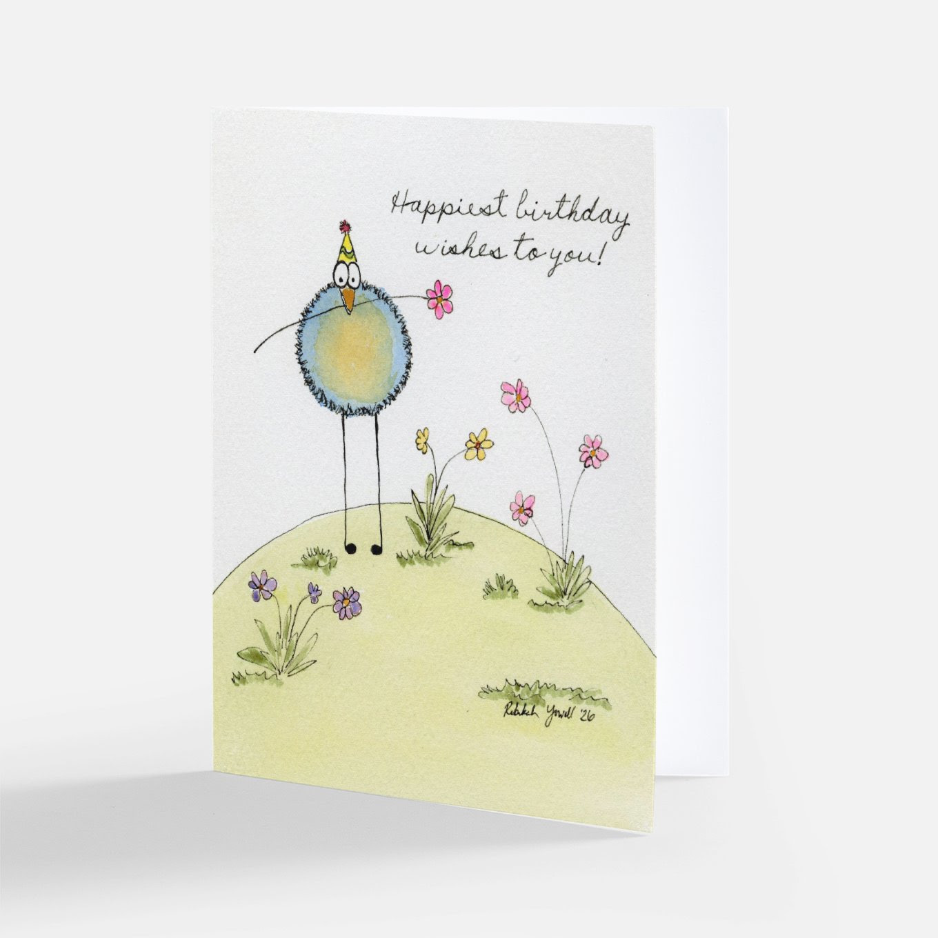 Whimsical watercolor birthday card of a fuzzy blue bird in a party hat holding a pink flower on a green hill, with "Happiest birthday wishes to you!"